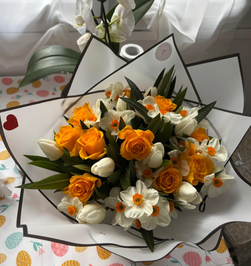 Composition de saison aux roses oranges, tulipes et narcisses